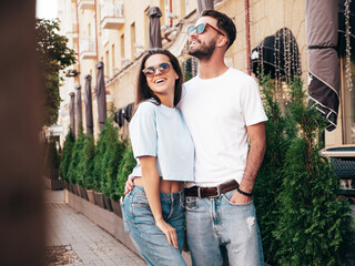 Plakat Smiling beautiful woman and her handsome boyfriend. Woman in casual summer jeans clothes. Happy cheerful family. Female having fun. Sexy couple posing in the street at sunny day. In sunglasses
