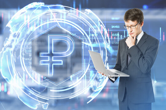 Thoughtful young european businessman with laptop using glowing ruble hologram on bright blurry office interior background. Money, digital banking and finance concept. Double exposure. - Powered by Adobe
