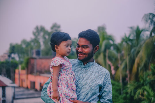South asian uncle holding his niece in outdoor park