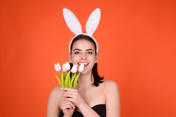 Woman with bunny ears and easter eggs. Easter bunny isolated on studio background. Holidays, spring...