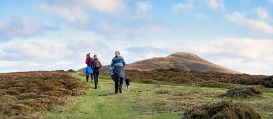 Friends hiking on mountain under cloudy sky