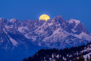 Austria, Tyrol, Yellow moon rising overWiedersbergerHorn at dusk