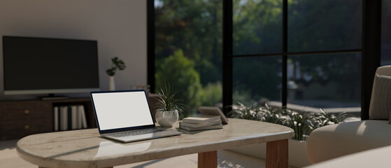 Portable laptop mockup on coffee table in modern contemporary living room. home workplace
