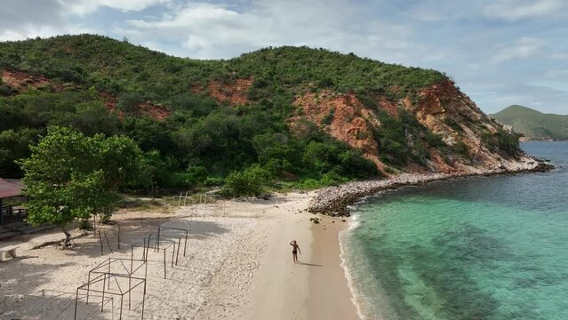 Lonely man walking on Playa Blanca beach, Mochima National Park, Venezuela.