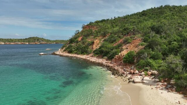 Aerial moving drone view of Playa Blanca beach in Mochima National Park, Venezuela.