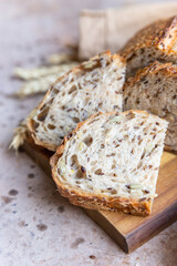 Sliced loaf of artisan sourdough bread with multigrain seeds. Tartine with honey and seeds on concrete background.