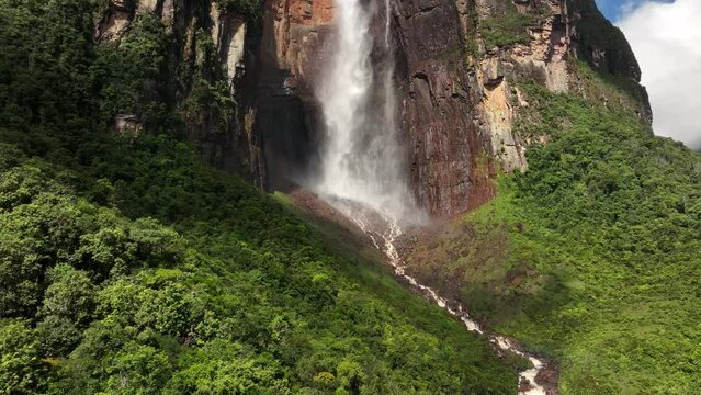 Camera moving closer to the lower part of Angel Falls in sunlight in Canaima National Park, Venezuela.