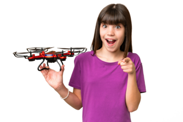 Little caucasian girl holding a drone over isolated background surprised and pointing front