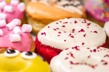 Delicious donuts of different flavors on paper close up.