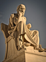 Socrates, the Greek philosopher, sited with a thoughtful expression, a marble statue. Cultural...