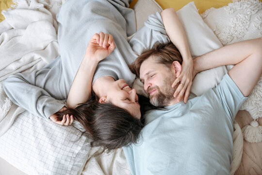 Smiling couple lying together on cushions at home