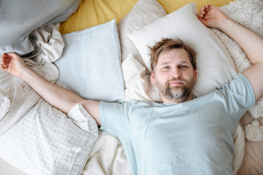 Man waking up on bed at home