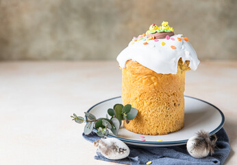 Easter composition with traditional Orthodox sweet bread. Kulich decorated with meringue icing, candy shaped eggs. Holiday concept.