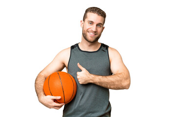 Obraz premium Handsome young man playing basketball over isolated chroma key background giving a thumbs up gesture