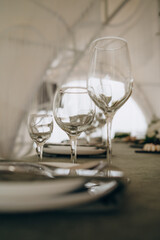 Wedding. Banquet. The chairs and round table for guests, served with cutlery, flowers and crockery and covered with a tablecloth