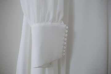 beautiful bride with brunette hair dressed in a white dress on the grey background. wedding dress with stylish sleeves, neckline decorated with lace. copy space