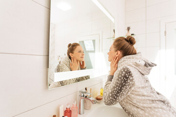 Woman looking in mirror at home