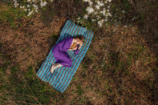 Woman relaxing on mattress at garden