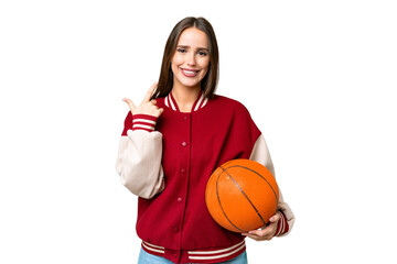 Young beautiful woman playing basketball over isolated chroma key background giving a thumbs up gesture