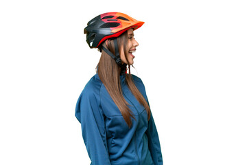 Young cyclist woman over isolated chroma key background laughing in lateral position