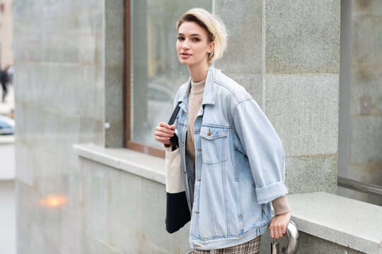 young beautiful woman pose in blue denim jacket outside in summer