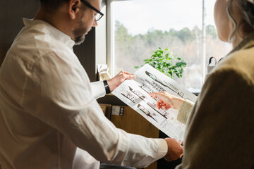 Two colleagues working on construction plan in architect's office