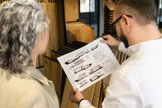 Two colleagues working on construction plan in architect's office
