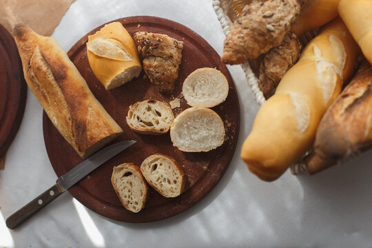 rye, wheat, multigrain baguettes in a basket, pieces on a wooden board