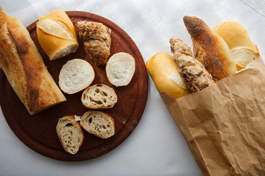 rye, wheat, multigrain baguettes paper bag, wooden board  pieces