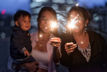Latino Mother Grandmother and baby boy celebrating with sparklers