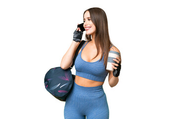 Young sport woman with sport bag over isolated chroma key background holding coffee to take away and a mobile