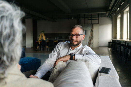 Portrait of confident businessman having a break in office sitting on couch