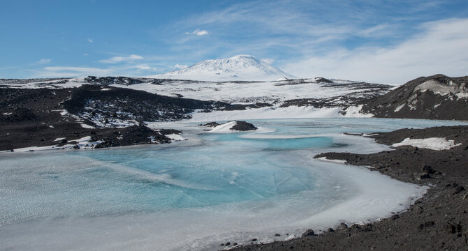 A frozen lake at Cape Royds, Antarctica with Mount Erebus behind