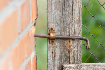 Old rusty latch on the door.Rusty homemade latch on a wooden door in the village.The concept of life in the village.
