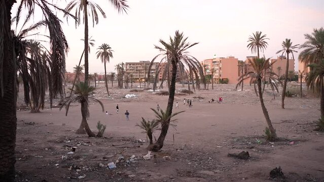 African kids playing football in a poor dirty neighborhood