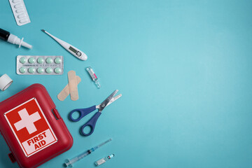 Home first aid kit on a blue background. The elements of the first aid kit
