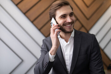 confident man businessman in a jacket speaks on the phone in the office