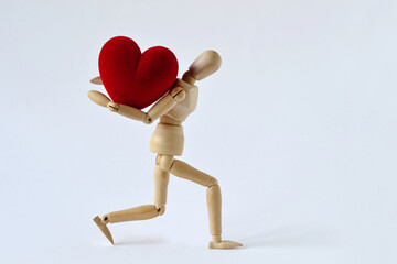 Wooden mannequin carrying heavy heart on his back - Concept of love, effort and heavy burden - obrazy, fototapety, plakaty