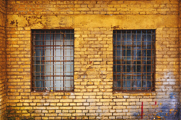 Fototapeta premium Old grid windows with dirty glass on exterior wall of an old abandoned factory warehouse building