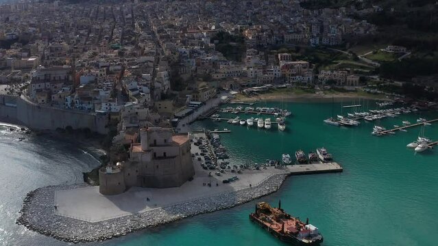 Aerial View Of Castello Arabo Normanno Located Beside Castellammare Del Golfo Port With Town View In Background. Parallax Shot