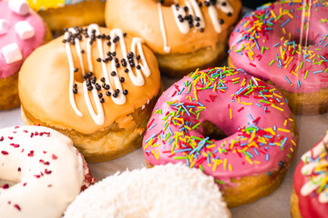 Delicious donuts of different flavors on paper close up.