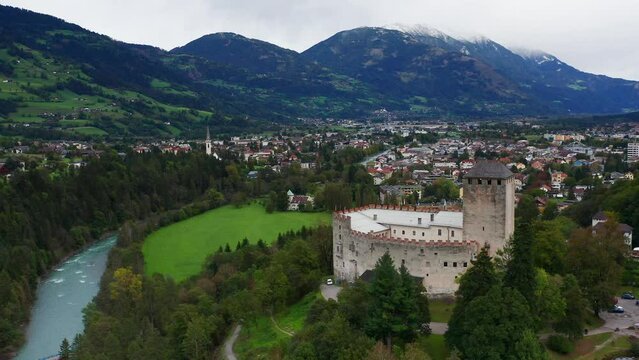 Aerial View Of Castle Bruck Beside River Isel In Austria With Town of Lienz In Background. Dolly Back
