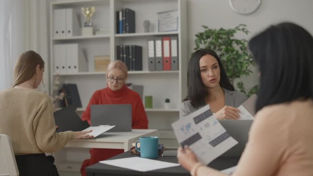 Different age women working with documents in all-female office safe environment