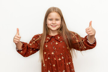 Photo of cheerful happy young small girl make fingers thumbs up smile recommend isolated on green...