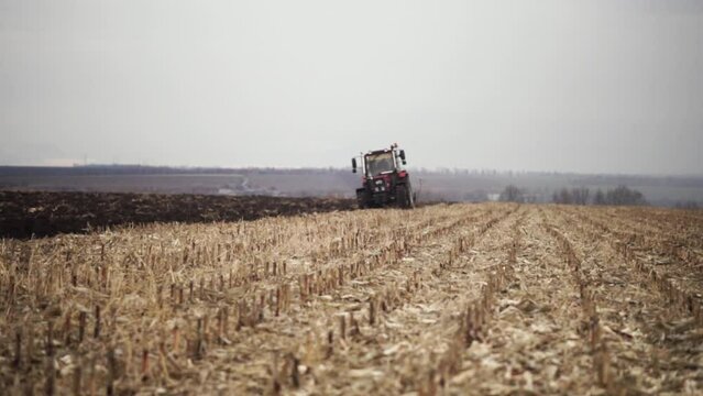 Red tractor plowing the field in Ukraine