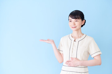 手で案内するエステ・美容クリニックの女性