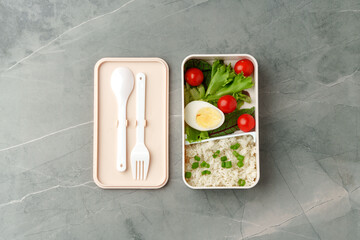 Lunch box with ready food on gray background