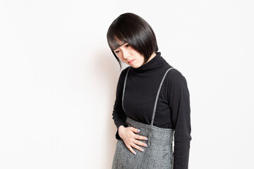 お腹を手で押さえている若い女性