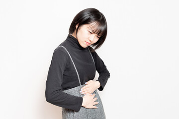 お腹を手で押さえている若い女性