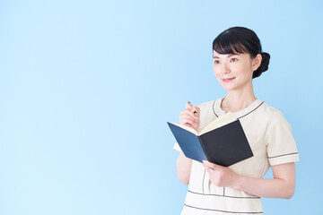 Obraz premium 手帳を書くエステ・美容クリニックの女性